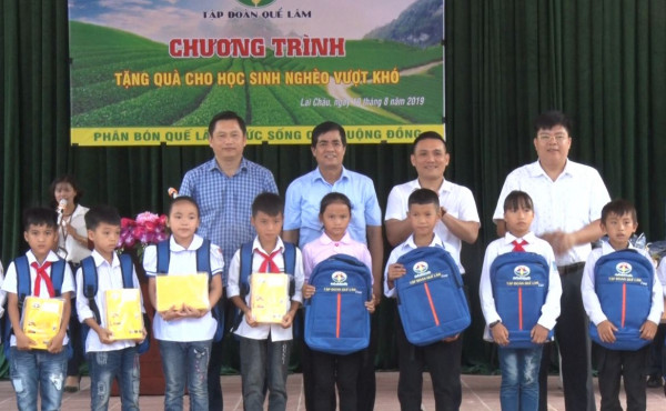 Các đồng chí lãnh đạo huyện ủy, UBND huyện, tập đoàn Quế Lâm trao quà cho học sinh