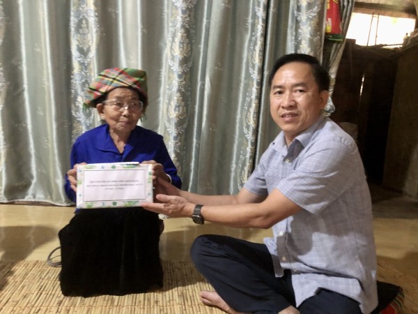 Đ/c Trần Quang Chiến phó chủ tịch UBND huyện trao quà cho mẹ Liệt Sỹ Tòng Thị Món ở bản Nà Đình xã Mường Kim