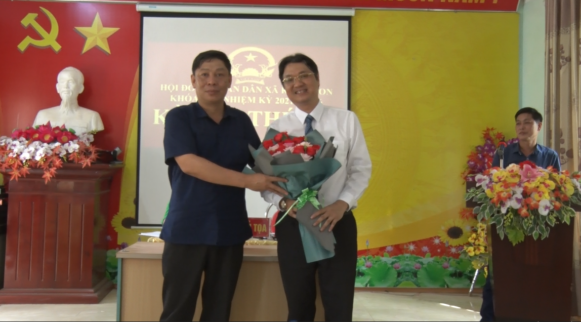 Đồng chí Hoàng Hữu An - TUV, bí thư huyện ủy, chủ tịch HĐND huyện tặng hoa chúc mừng tại kỳ họp